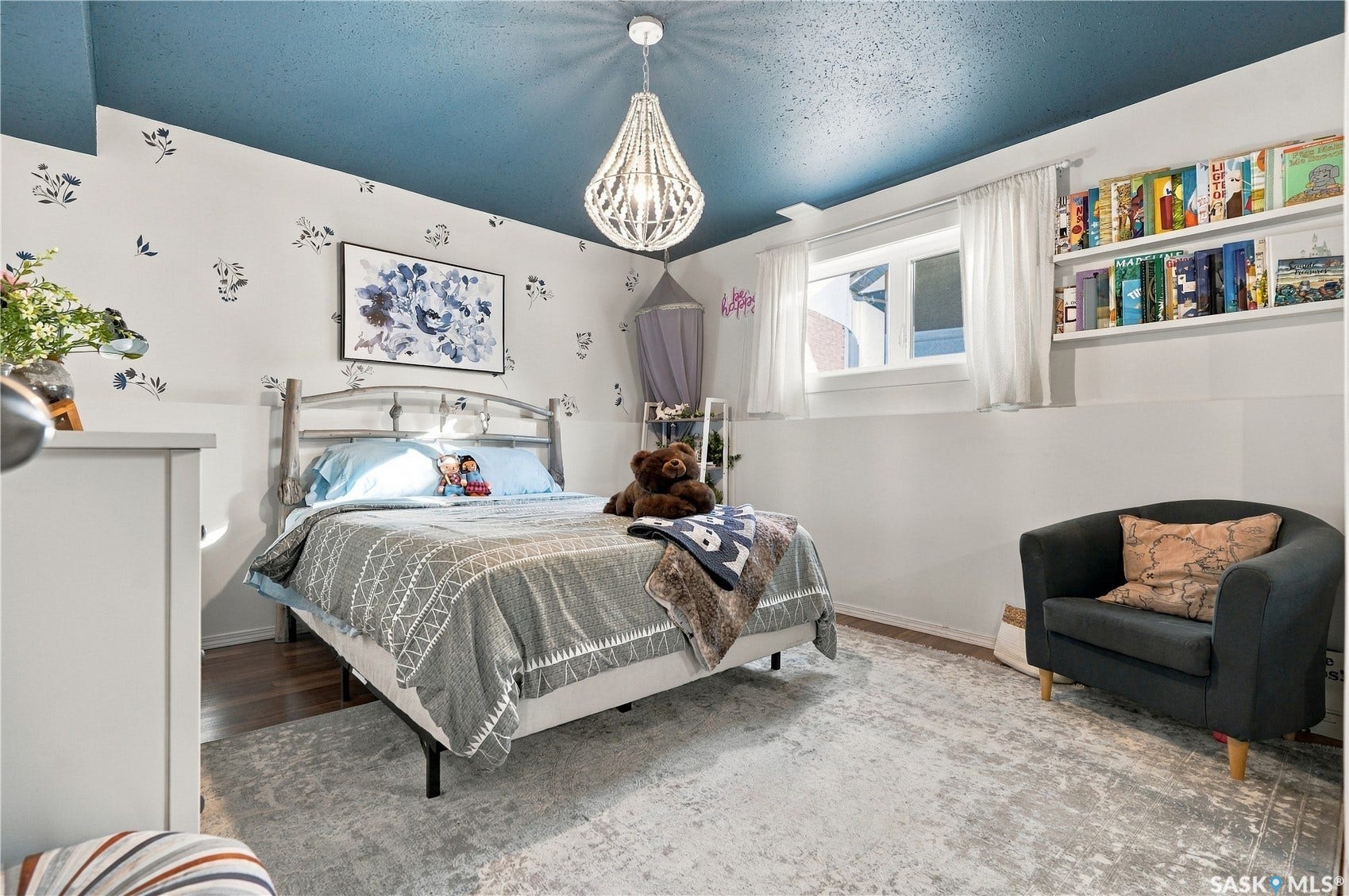 Wall-mounted shelving, wood-finish flooring, and a crystal chandelier