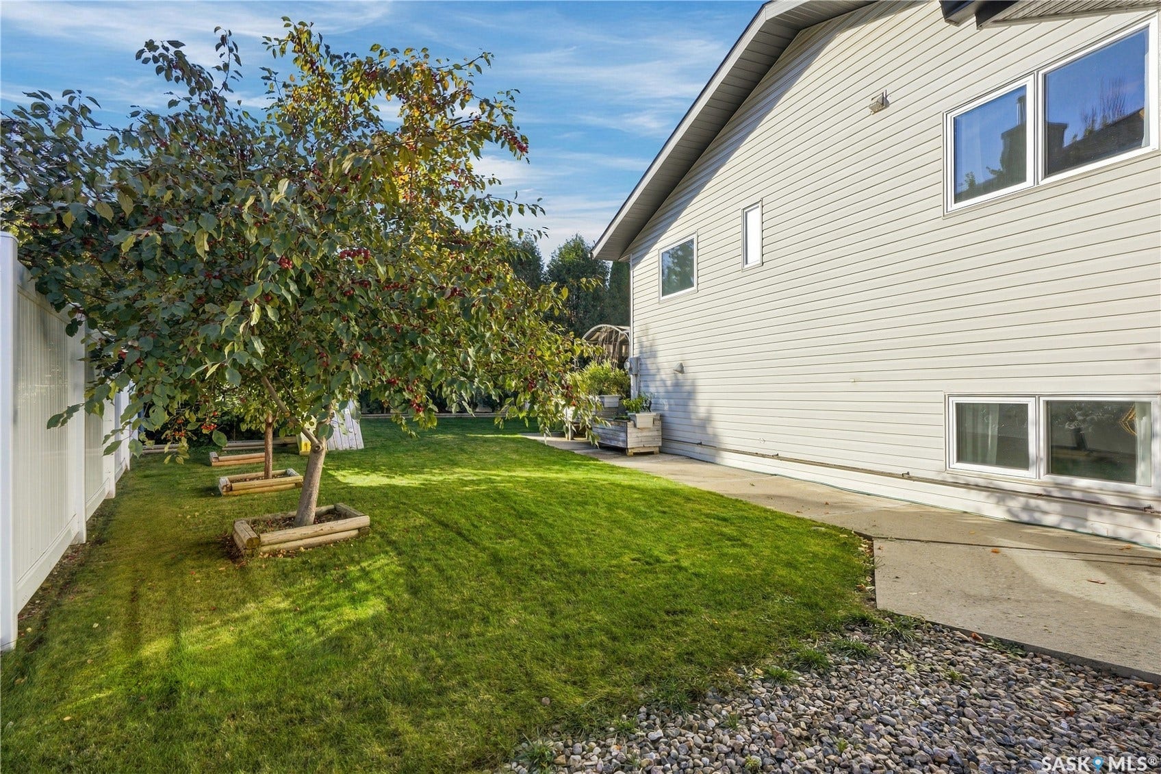 Expansive lawn area bordered by a white privacy fence