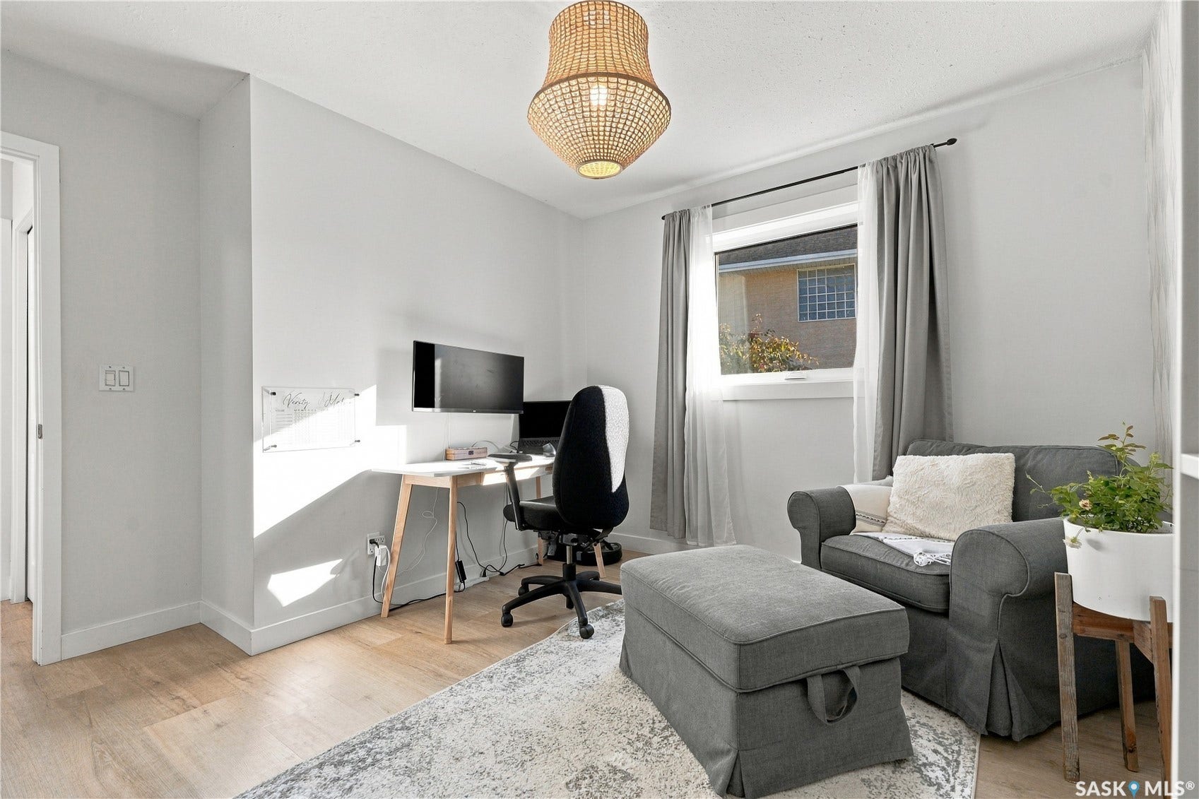 Recessed lighting, wood-finish flooring, and a single window with curtain rods