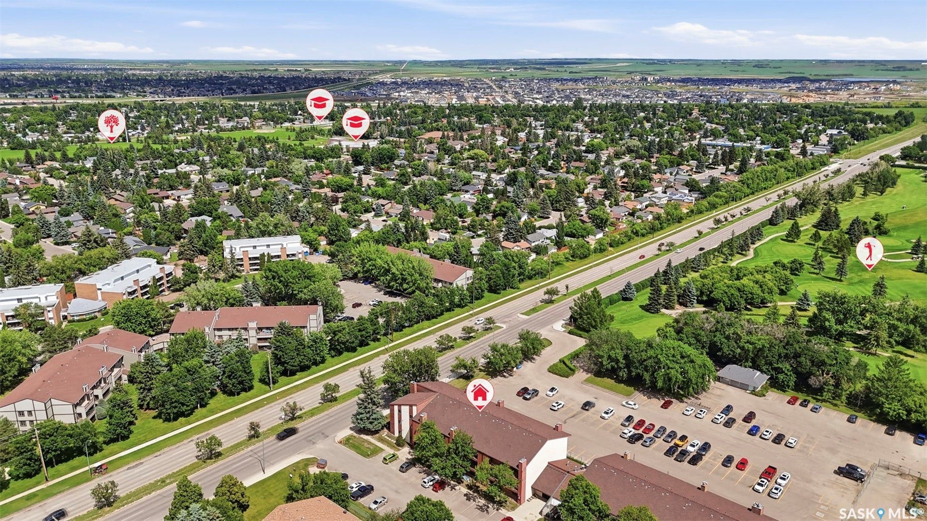 Expansive aerial perspective showcasing a residential area with extensive tree coverage and a large open green space