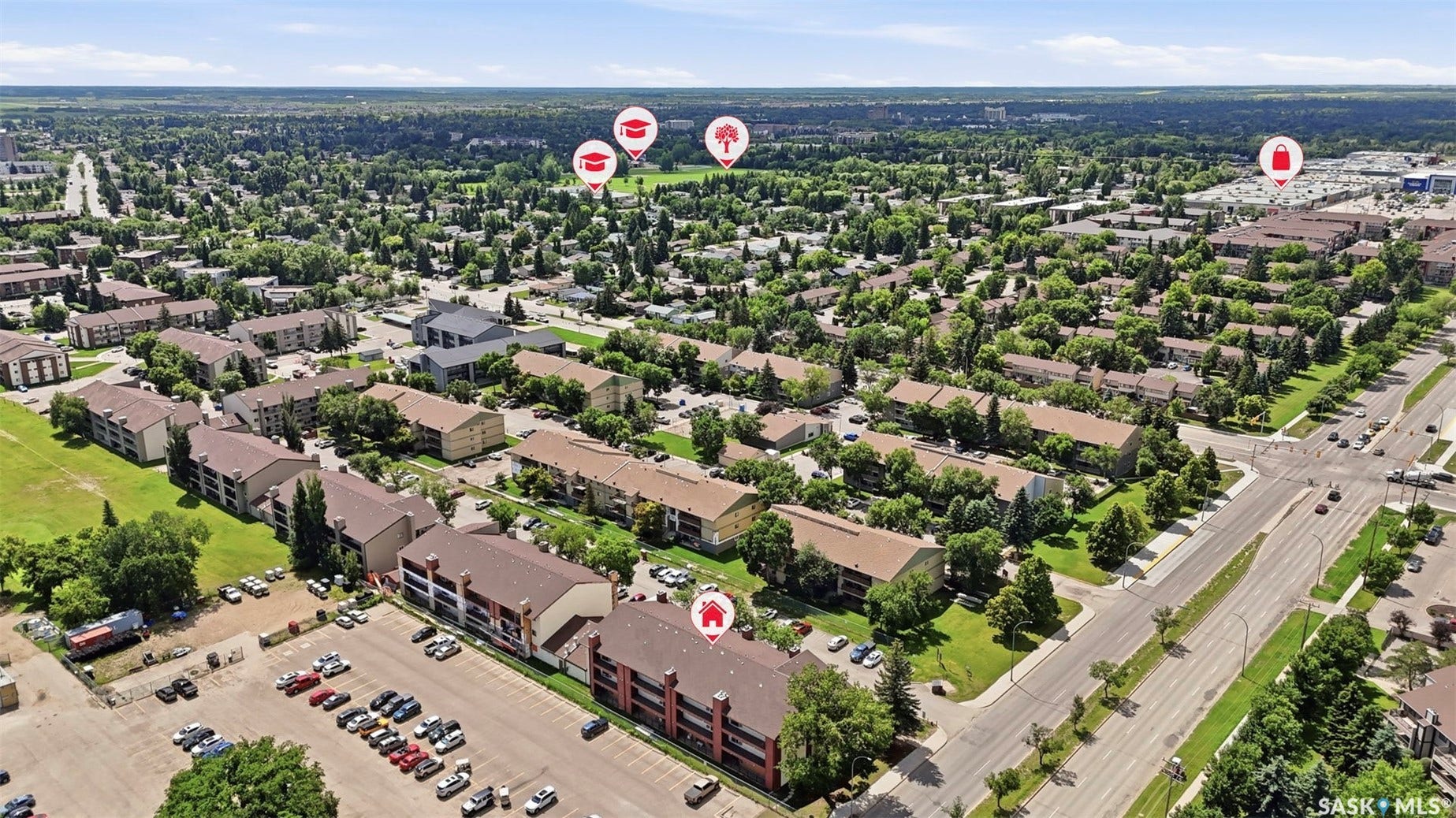 Aerial perspective showcasing a residential community with abundant mature trees and multiple multi-story buildings