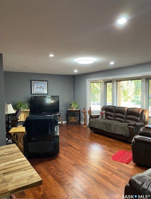 216 2nd Avenue, Wiseton SK S0L 3M0 Wood-finish flooring, recessed lighting, expansive windows, gray wall paint, and a built-in ceiling light fixture