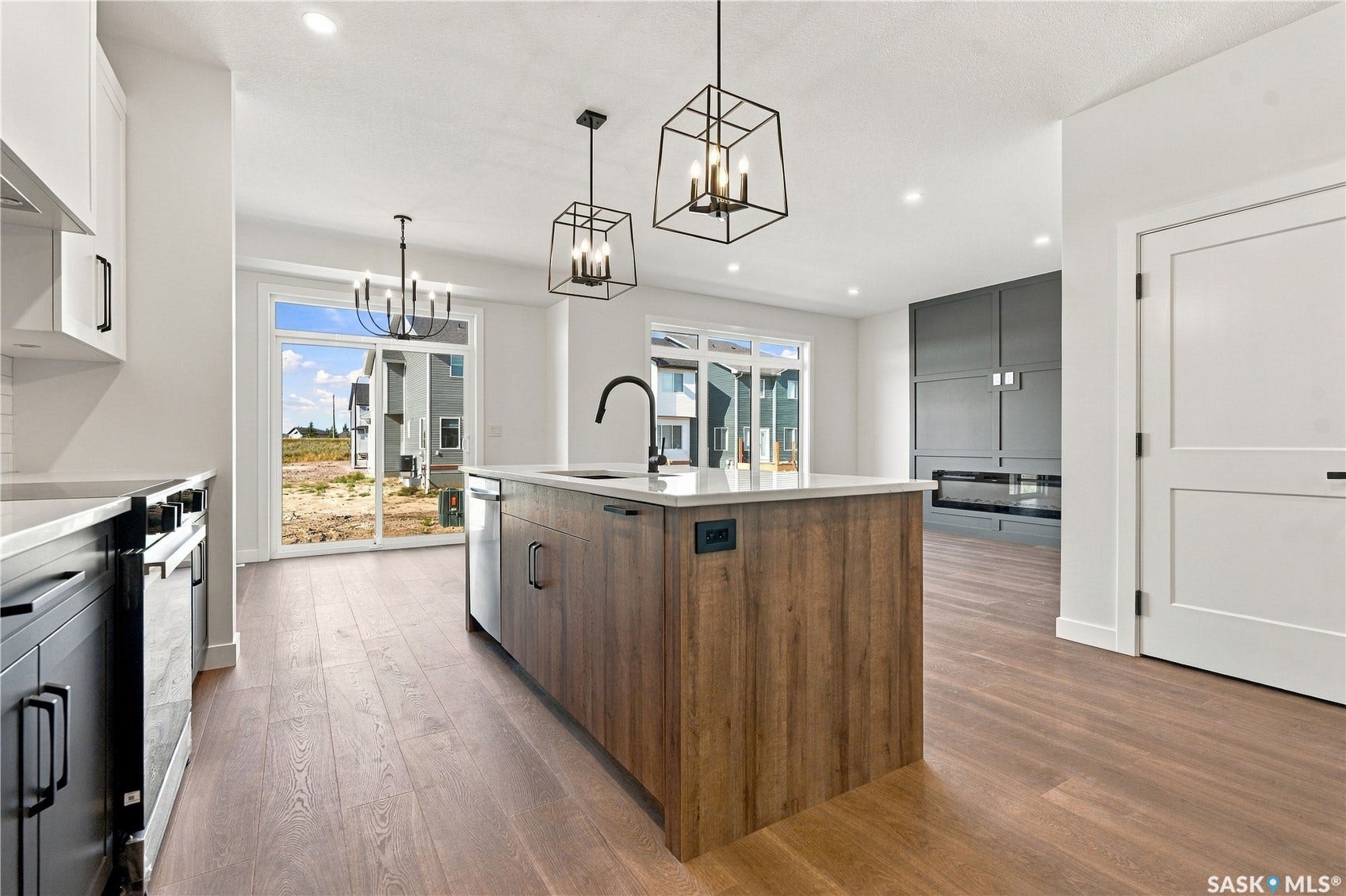Kitchen island with wood-finish cabinetry, white countertop, and black faucet