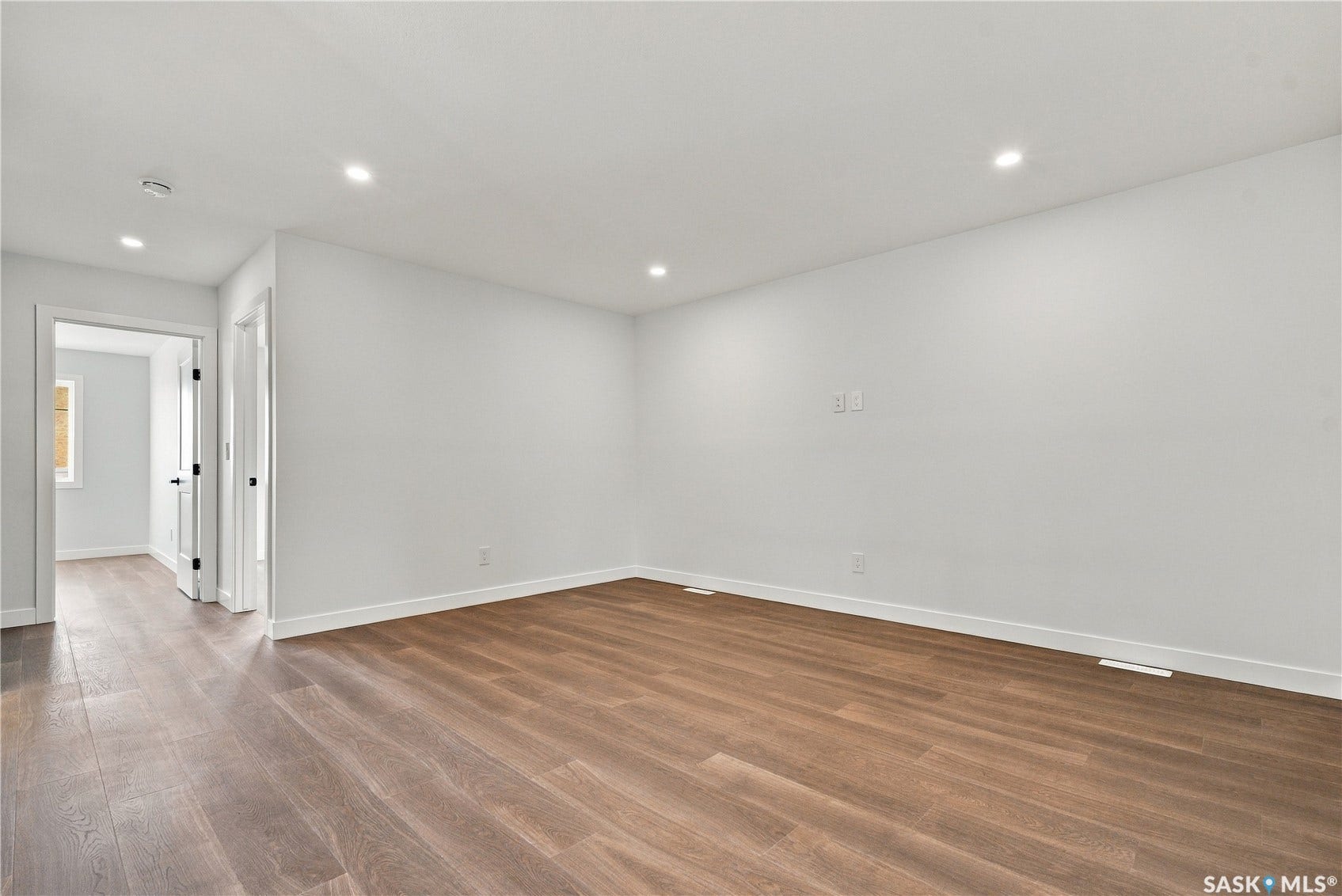 Recessed lighting, wood-finish flooring, white walls, and white trim throughout