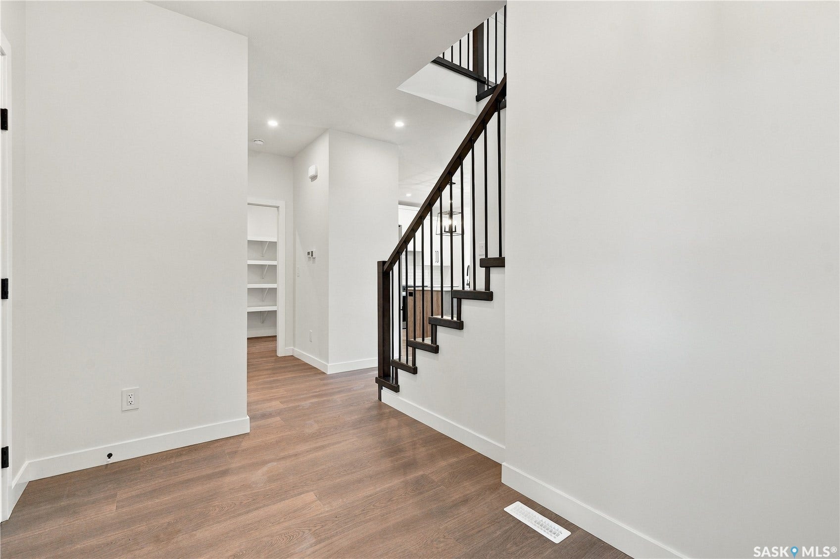 Staircase featuring dark wood treads and risers with black metal balusters