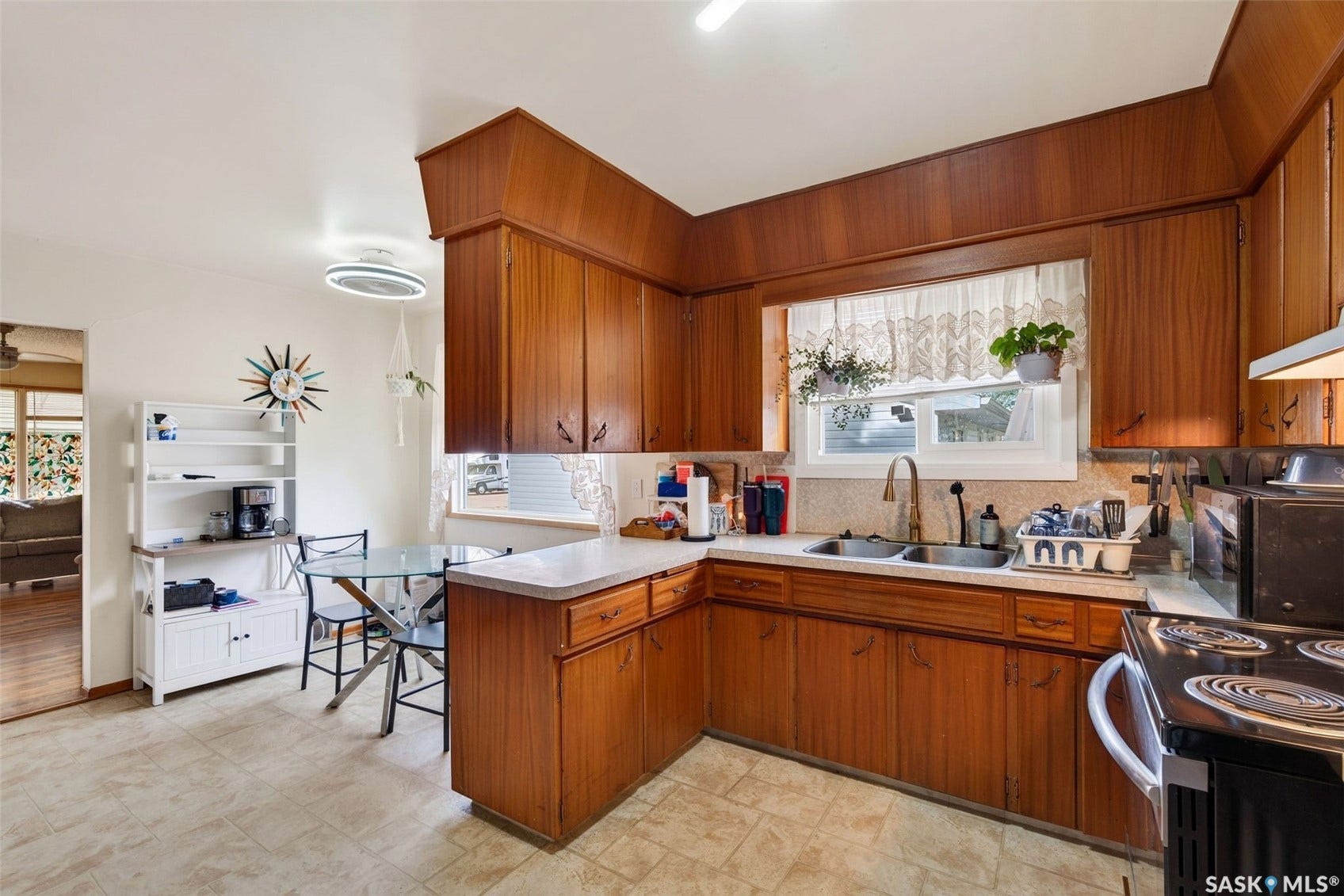 Wood-finish cabinetry with white countertops, double basin sink, and tile flooring