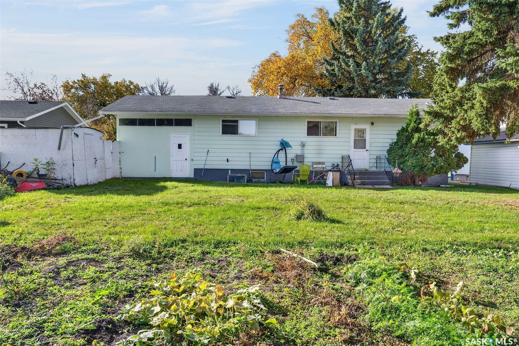 Expansive backyard space with a grass lawn, mature trees, and a detached shed