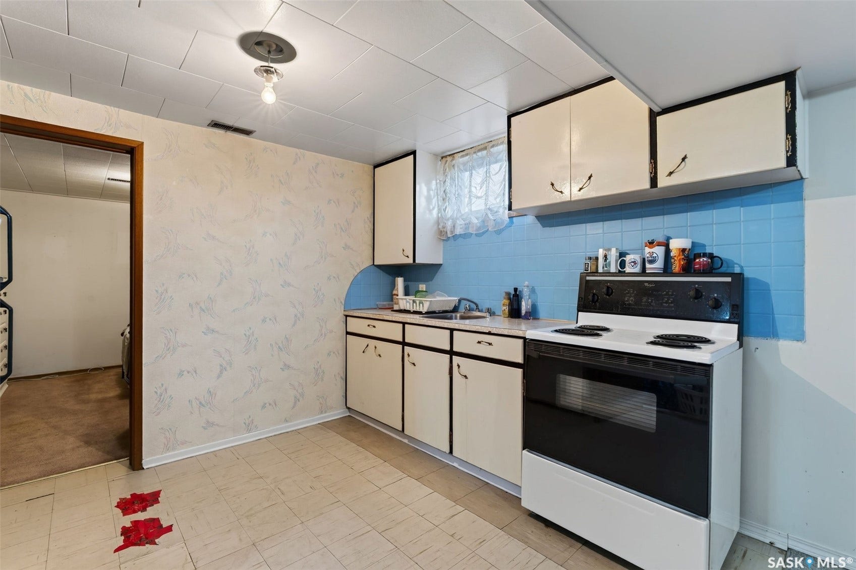 Kitchenette featuring white cabinetry, blue tiled backsplash, white appliances, and tiled flooring