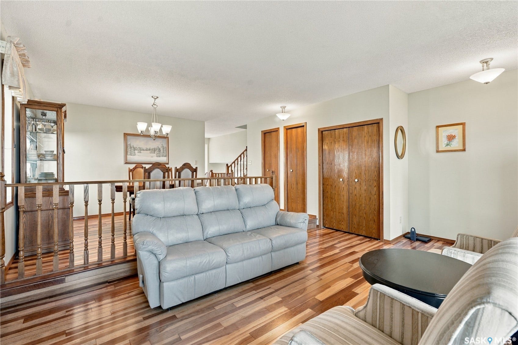 Wood-finish flooring throughout, light-toned walls, and wood doors