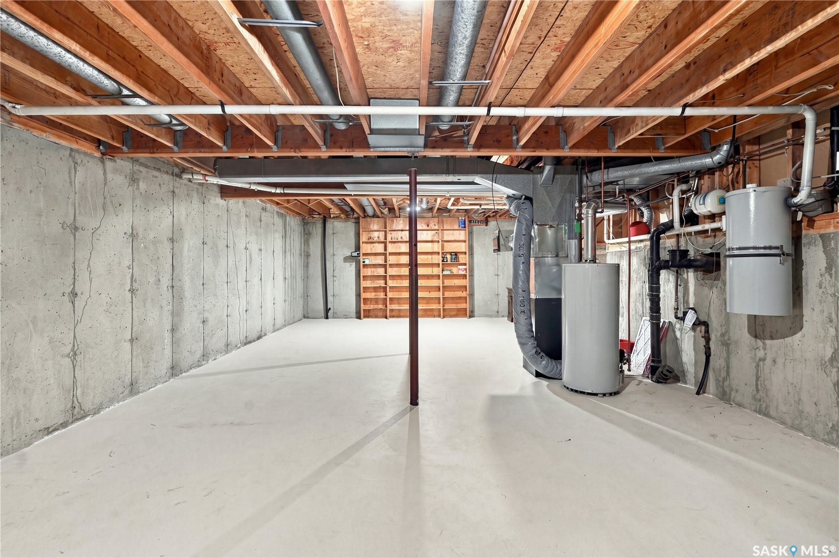 Unfinished basement featuring exposed wood joists, concrete walls, and painted concrete flooring