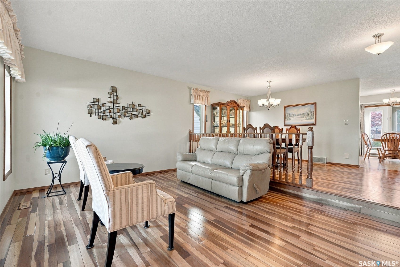Wood-finish flooring throughout, with a distinct raised platform separating living areas