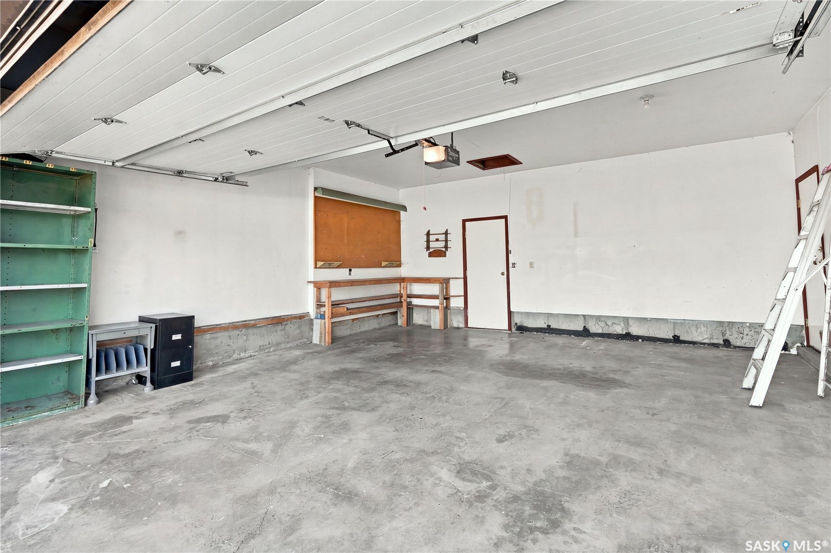 Concrete flooring, white walls, and a white garage door