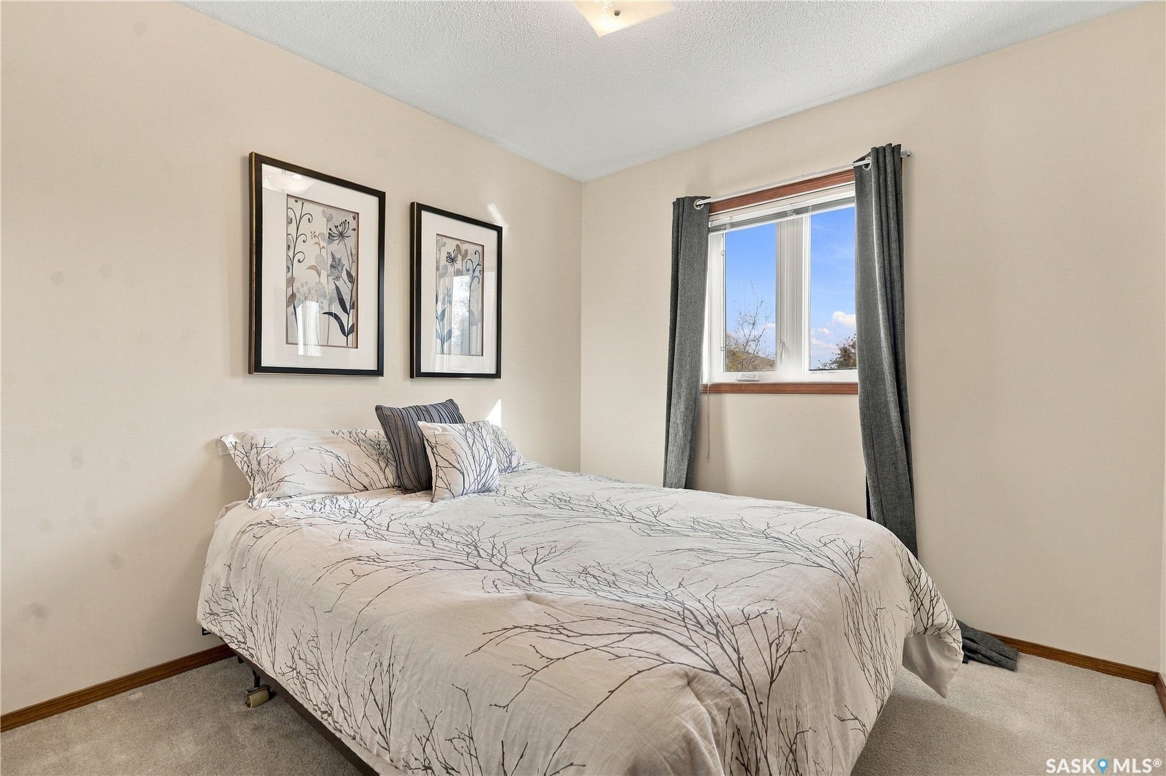 Neutral tone wall paint, light-colored carpet flooring, white trim window, wood-finish window sill