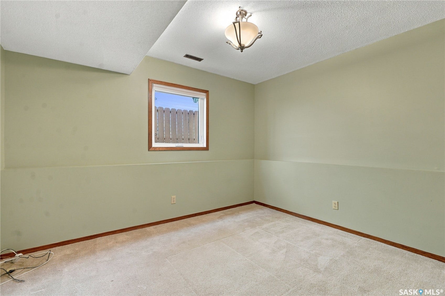 Recessed window with wood-finish trim, ceiling-mounted light fixture, and carpeted flooring
