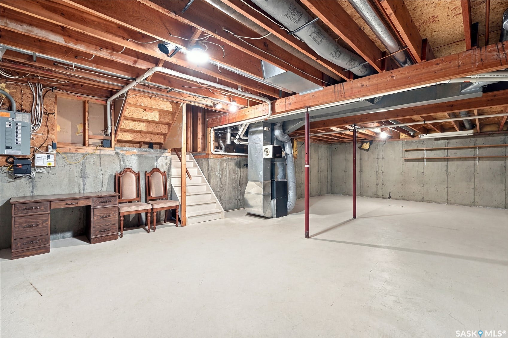 Unfinished basement with exposed ceiling joists, concrete walls, and concrete flooring