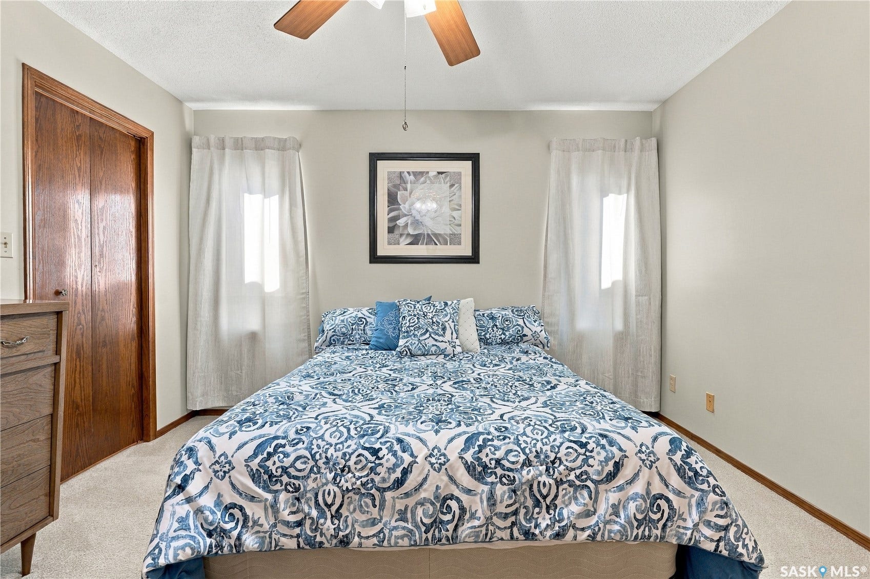 Neutral wall color, ceiling fan, wood-finish bi-fold closet doors, wall-to-wall carpeting