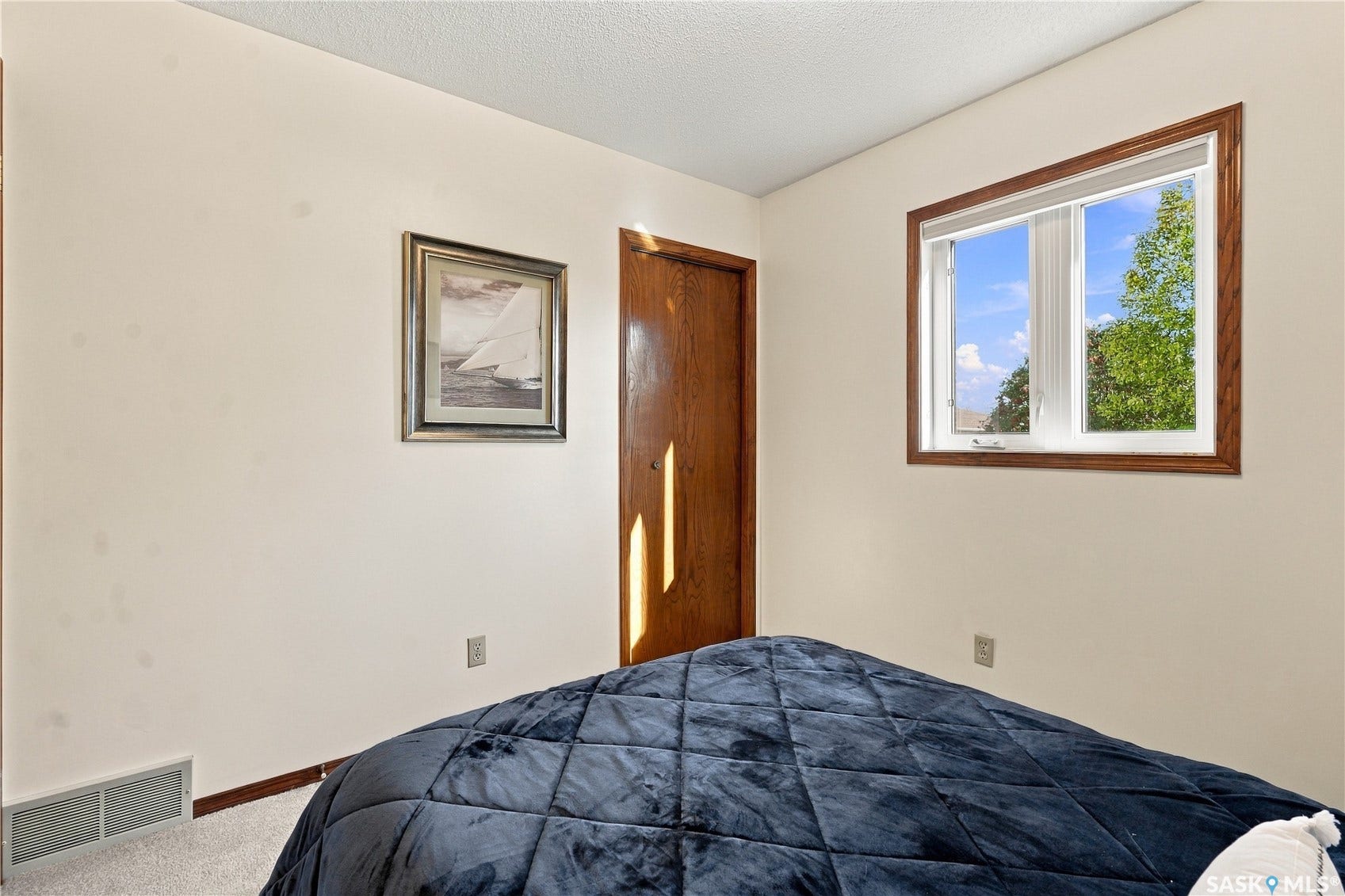 Window with wood-finish trim, neutral wall color, and light-colored carpet