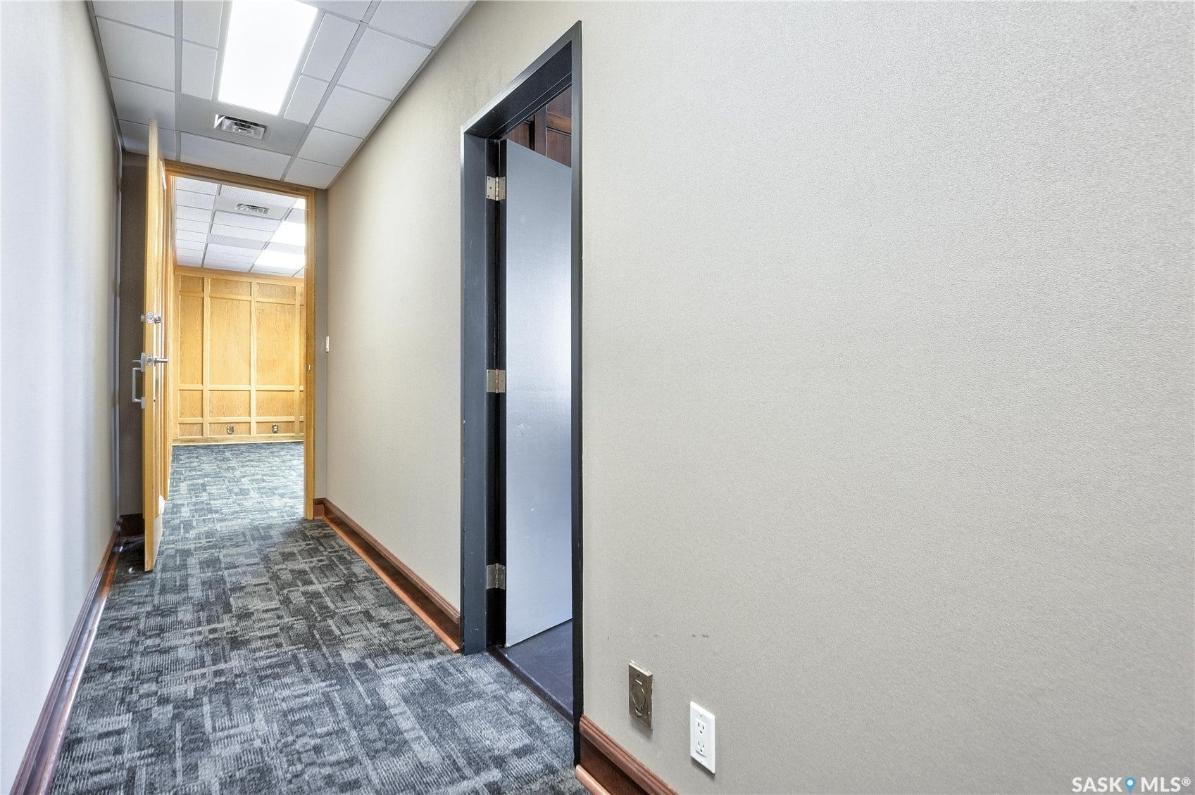 Recessed lighting, drop ceiling, patterned carpet flooring, wood baseboards, and neutral wall tones