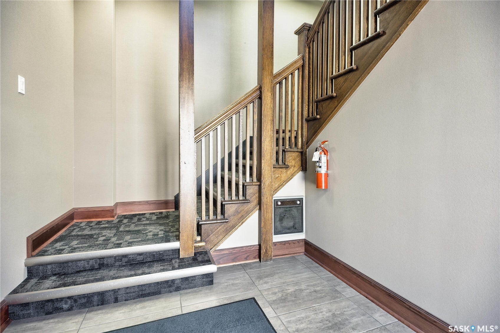 Wood staircase featuring wood balusters and a wood handrail