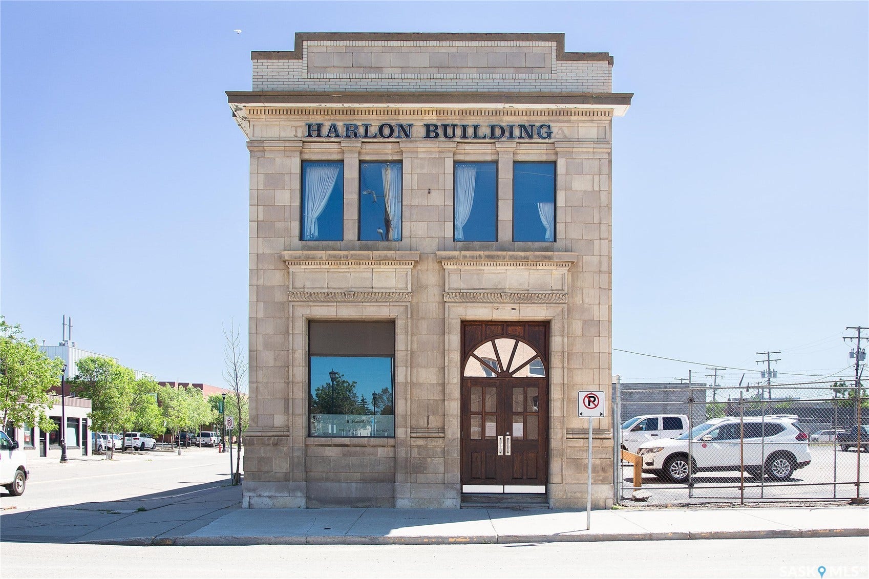 Stone facade with decorative cornice and arched double entry doors