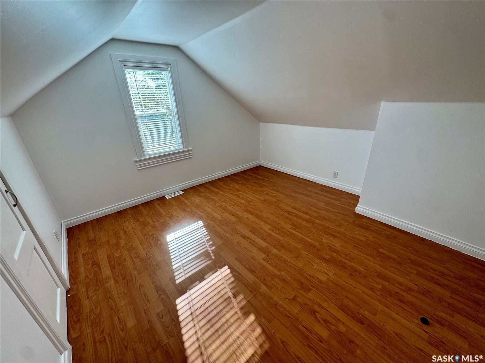 365 Keats Street, Southey SK S0G 4P0 Attic space featuring wood-finish flooring, an angled ceiling, a window with blinds, and white trim