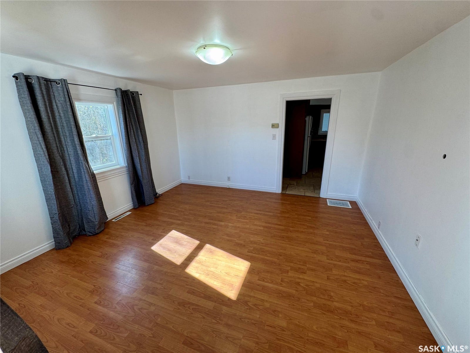 365 Keats Street, Southey SK S0G 4P0 Wood-finish flooring, white walls, and a window with trim