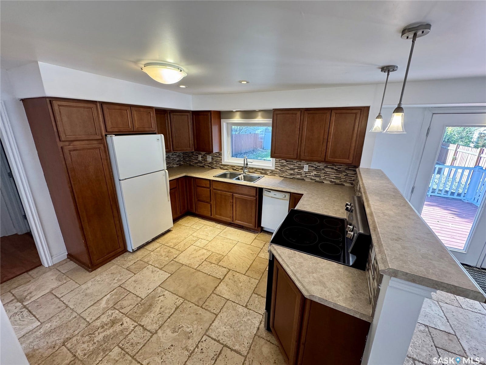 365 Keats Street, Southey SK S0G 4P0 Warm wood-finish cabinetry, patterned tile flooring, and integrated stainless steel appliances