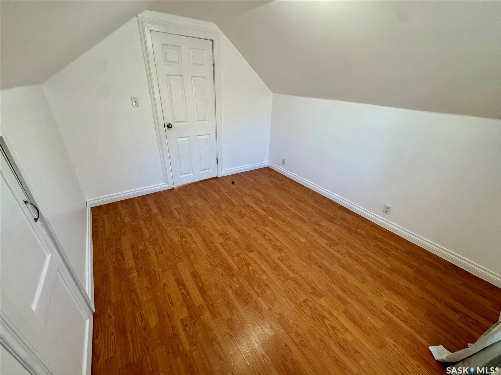 365 Keats Street, Southey SK S0G 4P0 Sloped ceiling design, white painted walls, wood-finish flooring, white panel door, and white trim