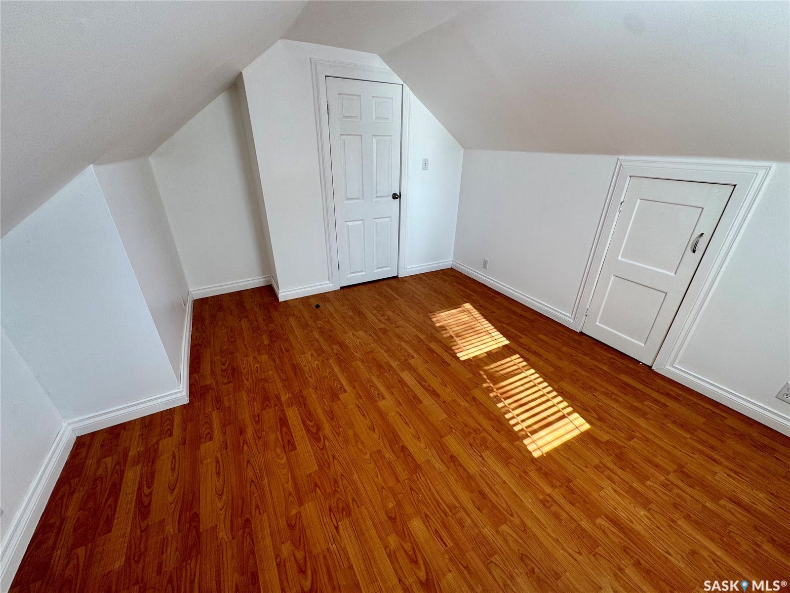 365 Keats Street, Southey SK S0G 4P0 Room featuring wood-finish flooring, white walls, and an angled ceiling