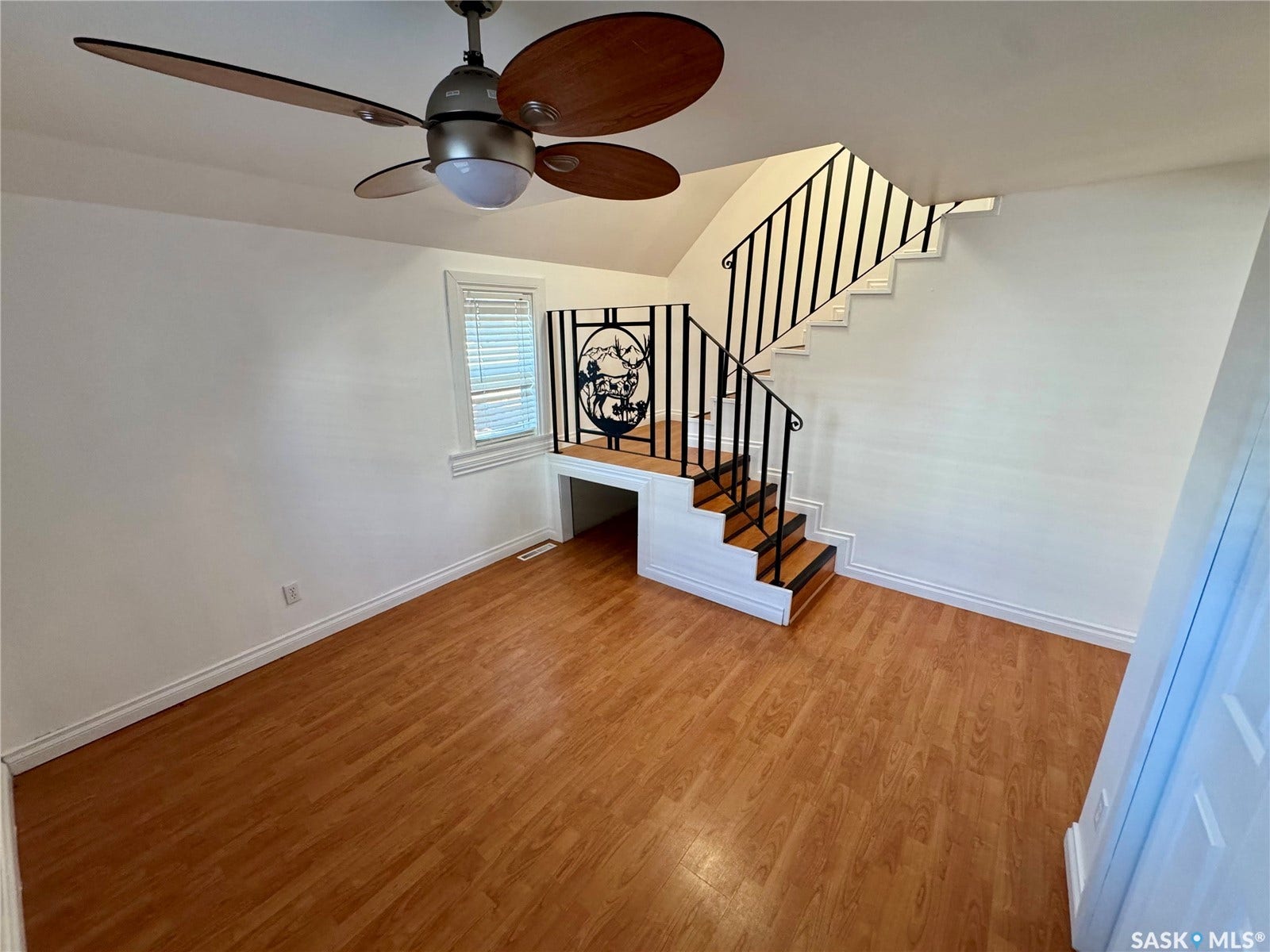 365 Keats Street, Southey SK S0G 4P0 Wood-finish flooring, staircase with metal railing, ceiling fan with integrated lighting, and window with blinds