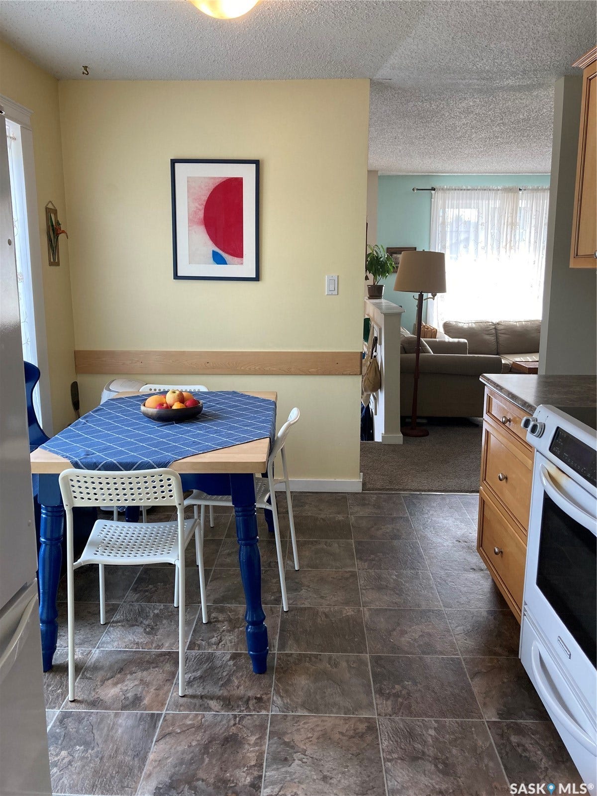 Tile flooring, ceiling-mounted light fixture, light-toned wall paint, partial wall, and built-in cabinetry