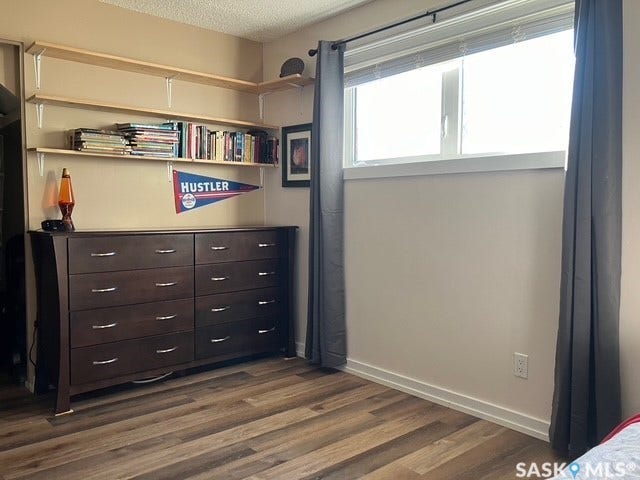 Wood-finish flooring, light-toned walls, and a large window with white trim