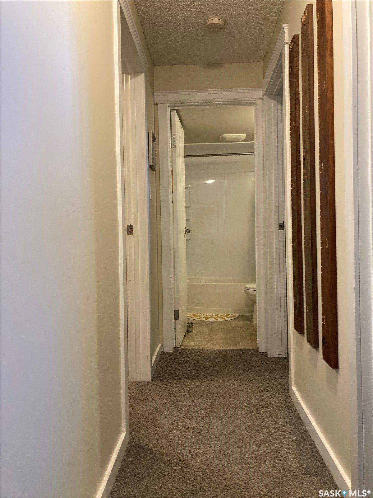 Hallway with neutral carpet flooring and white trim