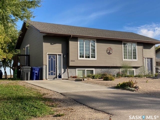Siding exterior with multiple windows, an asphalt shingle roof, and a concrete driveway