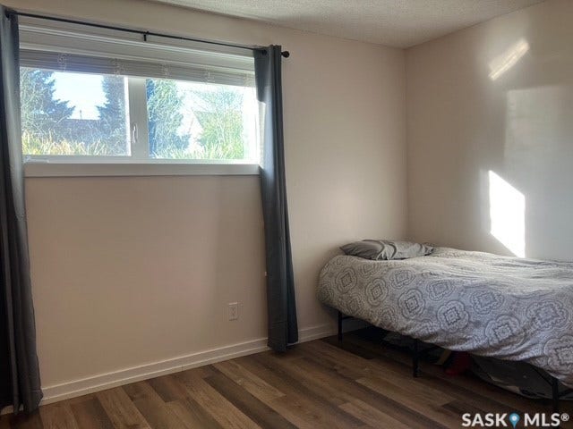 Hardwood-style flooring, white trim, and a window with a white frame