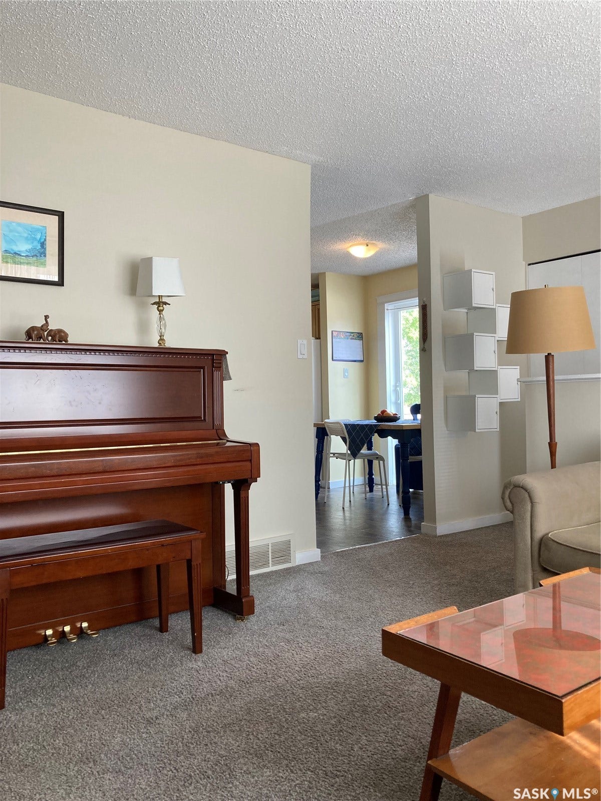 Carpeted flooring, light-toned wall paint, and a textured ceiling