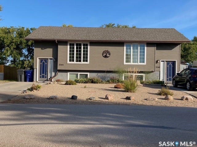 Split-level exterior featuring horizontal siding, a gabled roofline, and decorative front doors