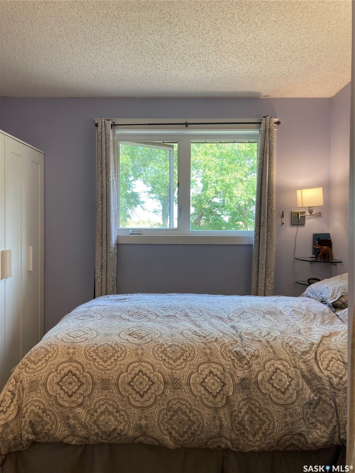 Double window with an operable casement, a built-in wardrobe, and a wall-mounted fixture