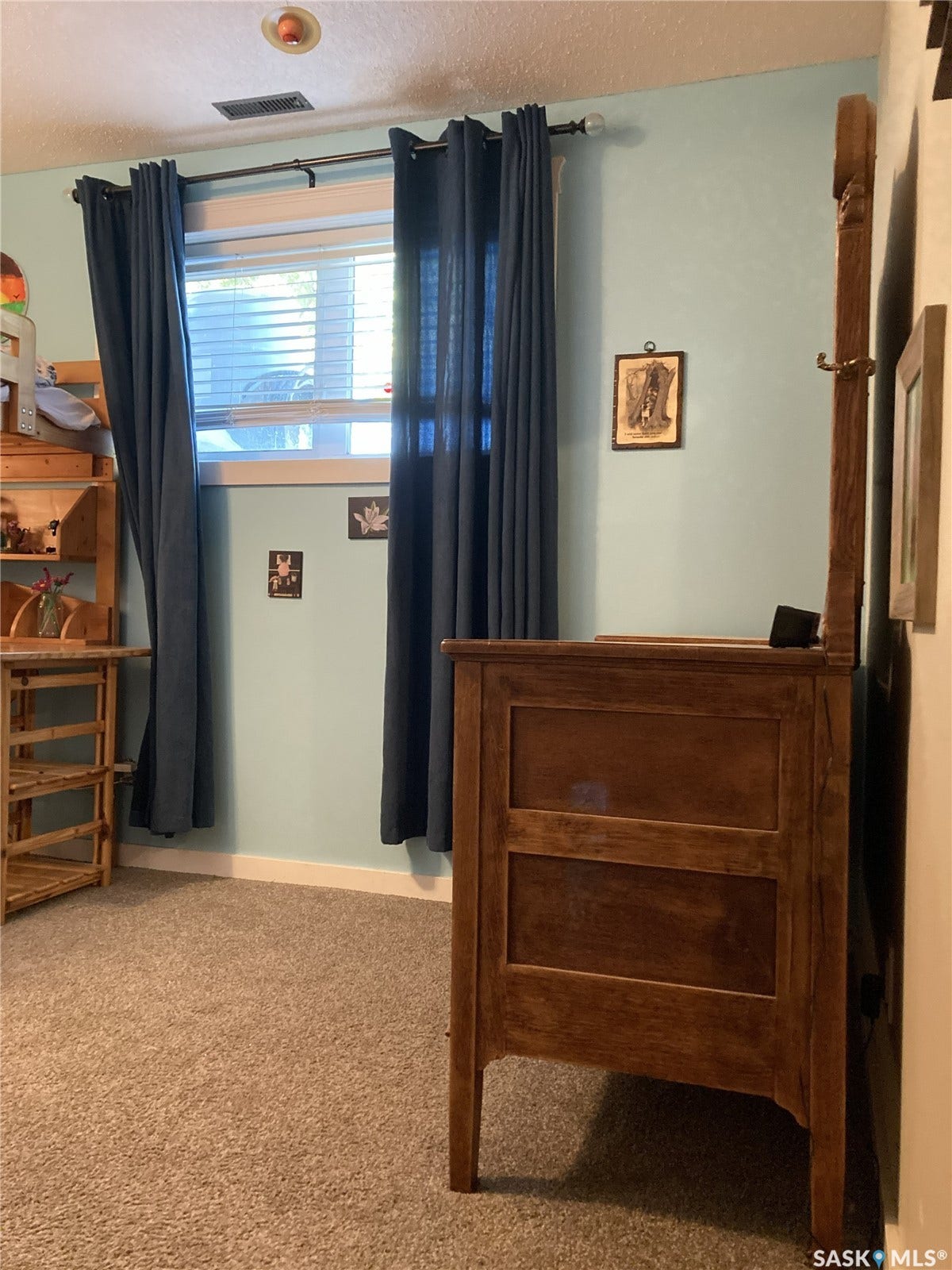 Carpeted flooring, light blue wall paint, window with blinds, and white trim