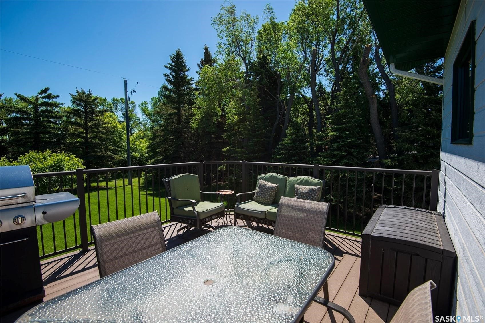 Expansive outdoor deck with composite decking, dark metal railings, and a solid exterior wall