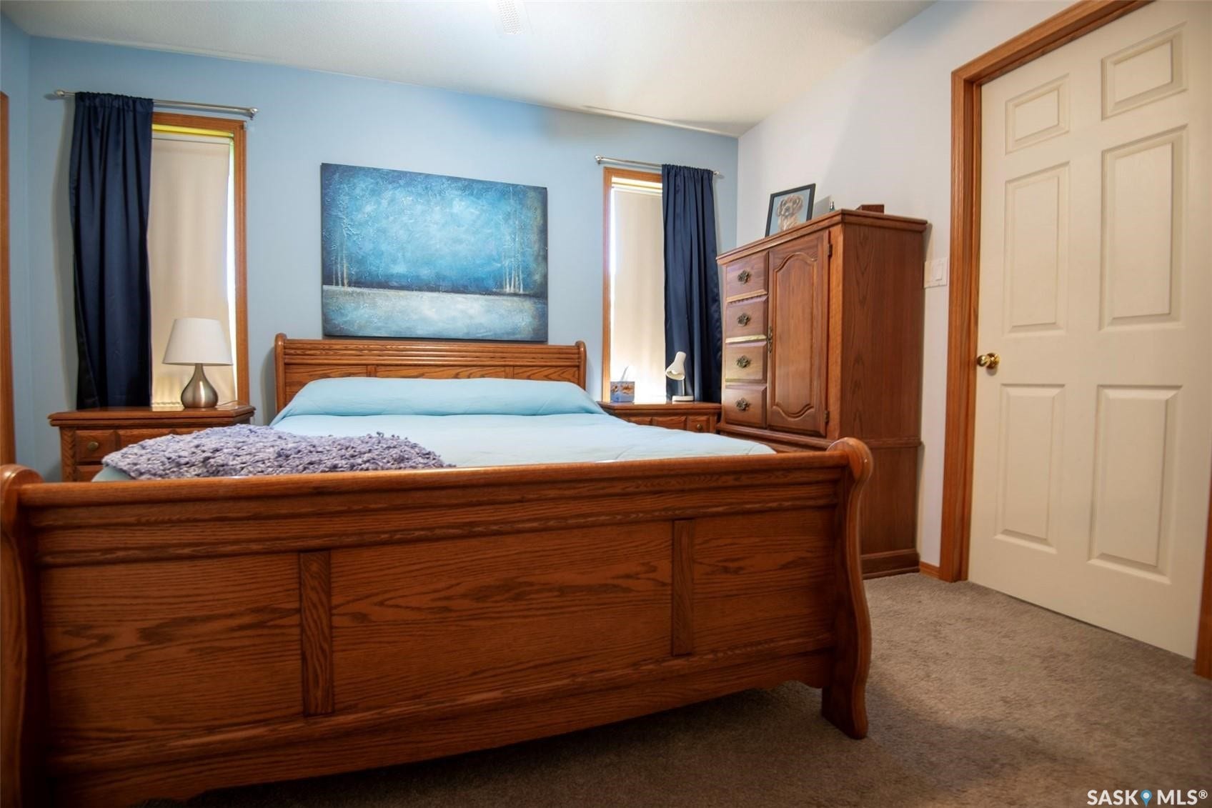 Carpeted flooring, paneled interior door, and light blue wall paint