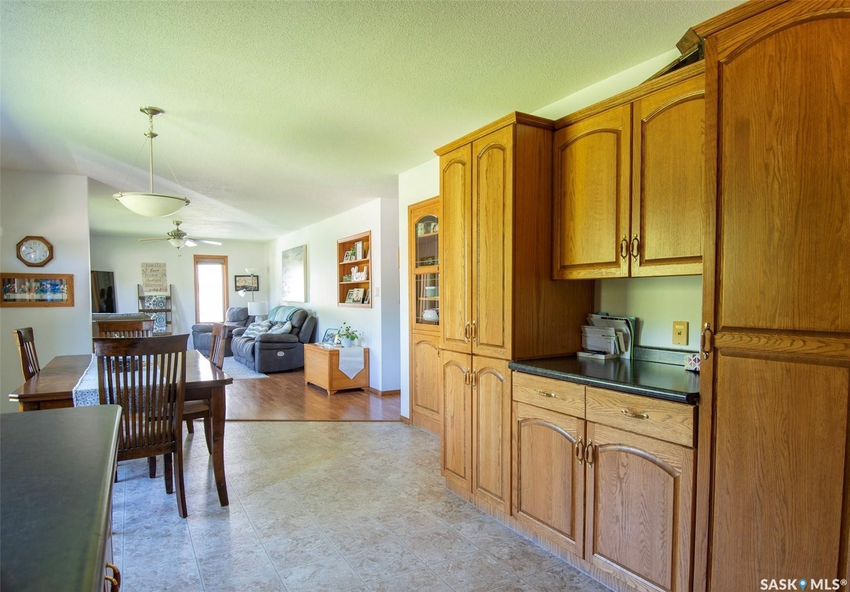 Wood-finish cabinetry with dark countertops and recessed shelving
