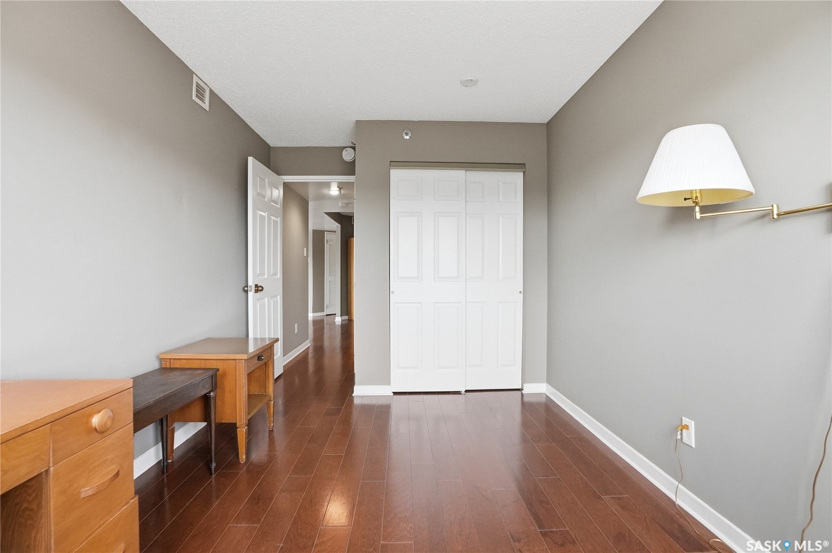 Wood-finish flooring, neutral gray wall tones, and white trim