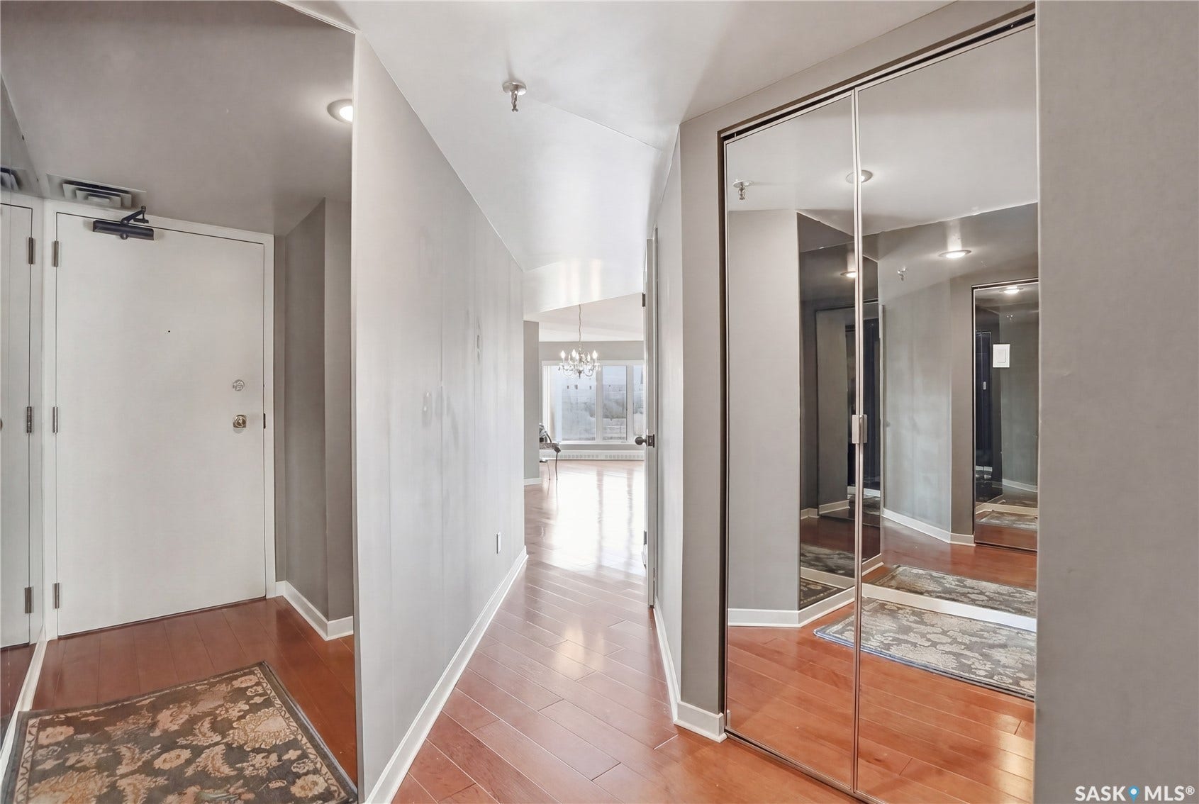 Hallway featuring wood-finish flooring, recessed lighting, and mirrored closet doors