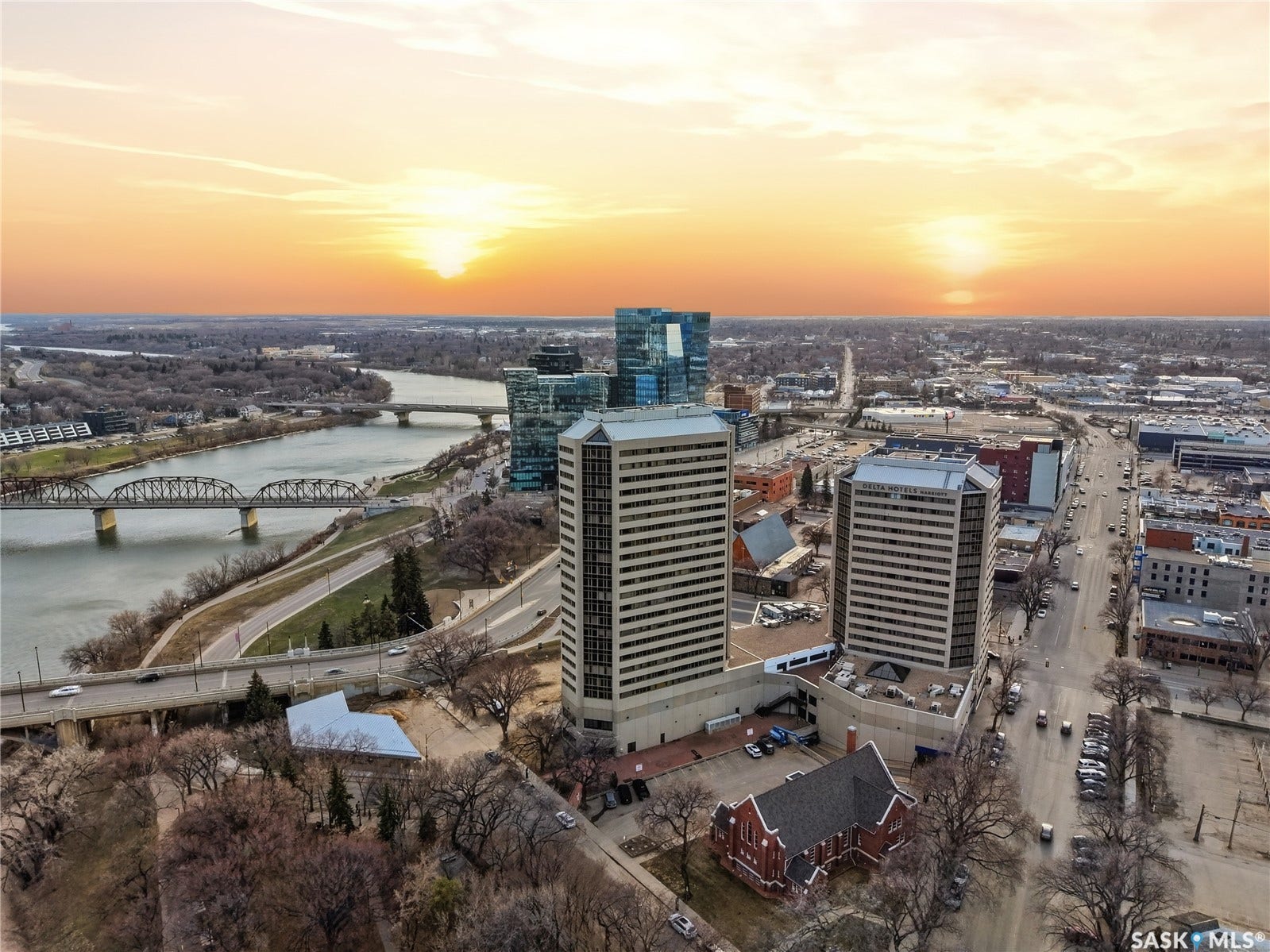Aerial perspective showcasing a major river with multiple bridges, urban skyline, and a prominent street with vehicles