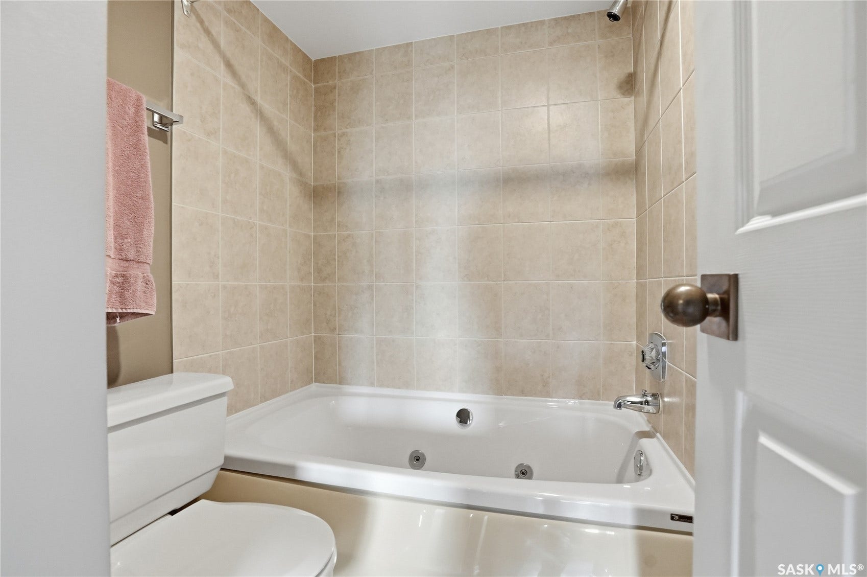 Tiled shower surround with a built-in bathtub and polished chrome fixtures