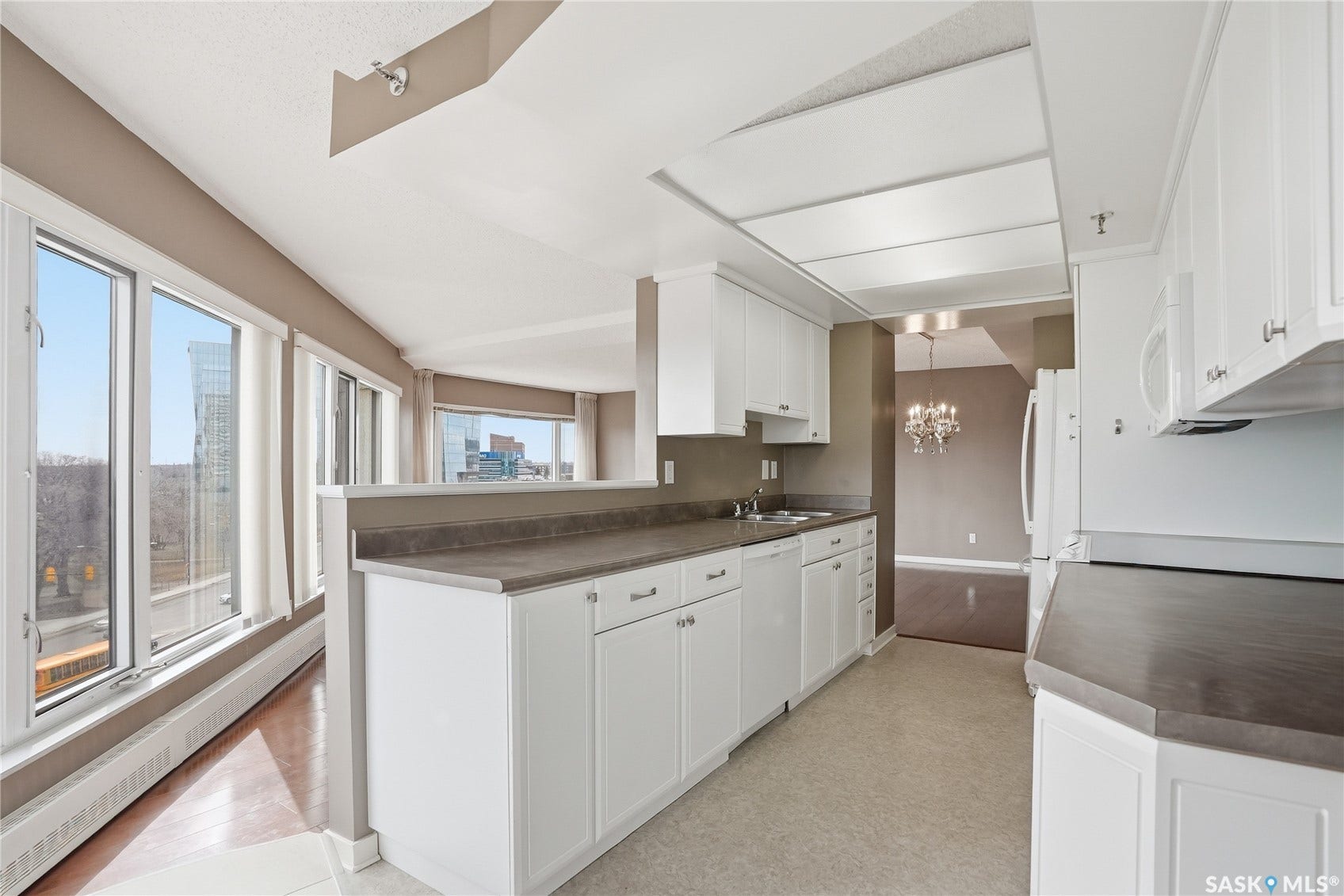 Kitchen featuring white cabinetry, grey countertops, and integrated appliances