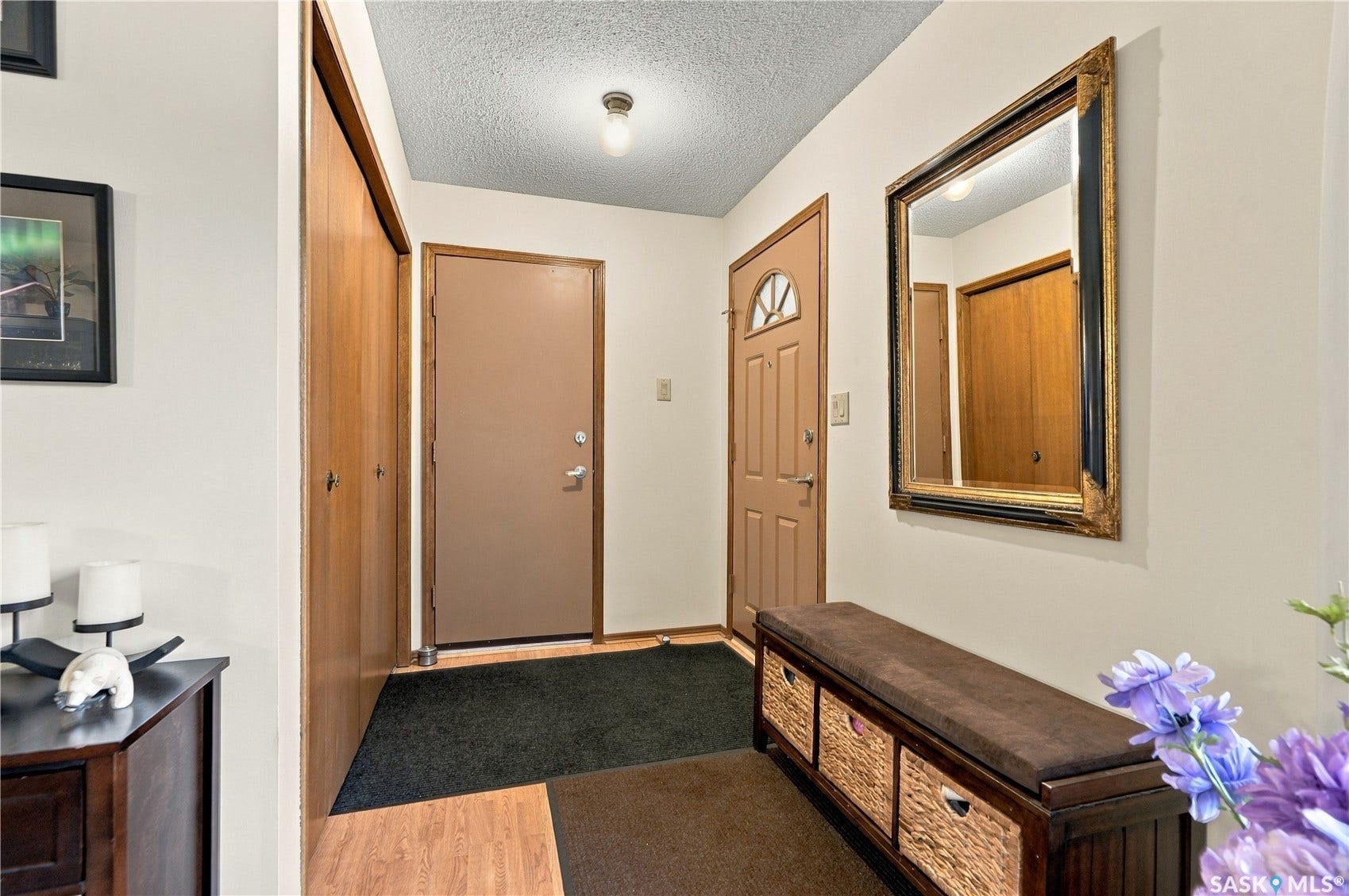 Entryway featuring wood-finish flooring, a flush-mount ceiling light, and a built-in closet with bi-fold doors