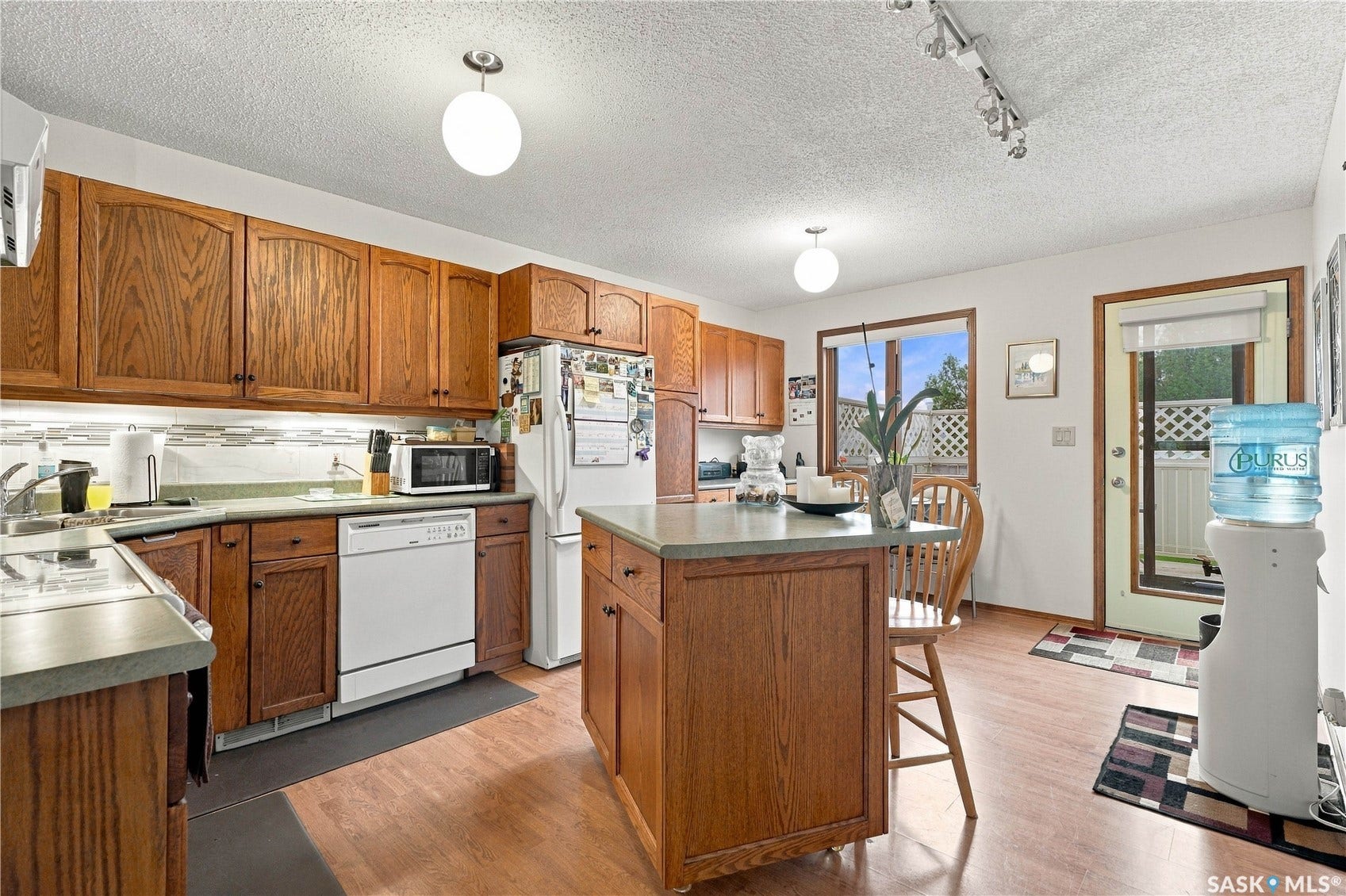 Kitchen featuring wood-finish cabinetry, a central island with countertop, and wood-finish flooring