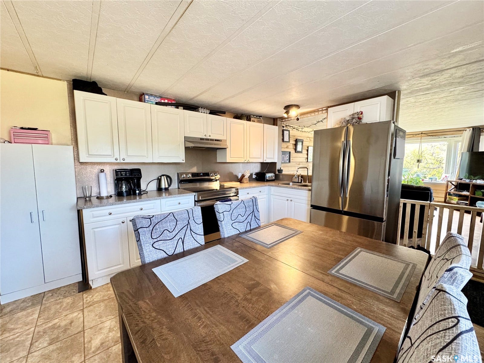 Kitchen featuring white cabinetry, stainless steel appliances, and tiled flooring